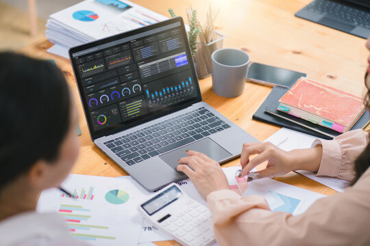 A businesswoman or accountant using laptop to analyze financial investments and business and marketing growth on a data graph. The concepts of accounting, economics, and commercial analysis.