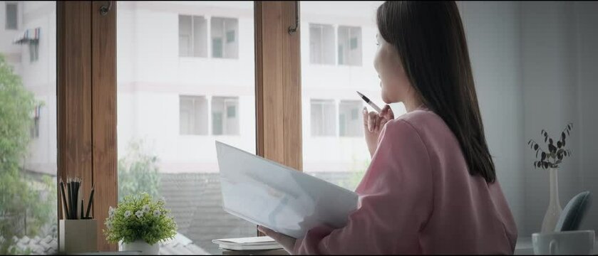 Side view of thoughtful businesswoman sitting at workplace and looking away, taking break, dreaming or visualizing