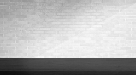 empty black minimal table for product displayed. black oak wooden table at foreground on white brick background with soft light beam. elegant scene for business advertising.