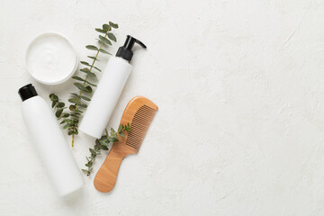 Professional hair care products with comb on concrete background, top view