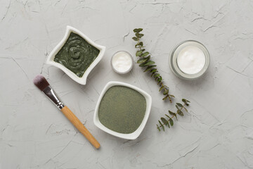 Composition with cosmetic clay and spa products on concrete background, top view
