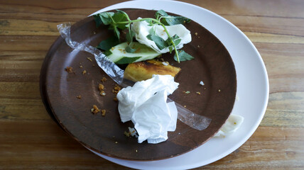 A brown plate fill with leftovers food, tissue, pipette plastic wrap, happened after finished...