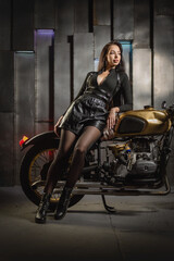 Naklejka na ściany i meble Young beautiful girl with dark hair on the old motorbike.