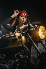 Obraz na płótnie Canvas Young beautiful girl with dark hair on the old motorbike.