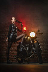 Young beautiful girl with dark hair on the old motorbike.