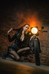 Obraz na płótnie Canvas Young beautiful girl with dark hair on the old motorbike.