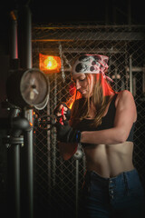 Plakat Girl with the wrench tool posing in the dark. Mechanic concept.