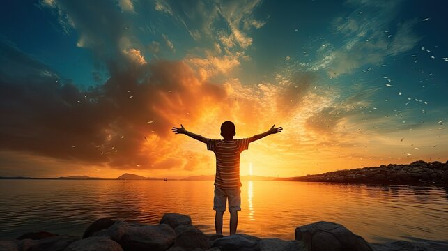 Boy s silhouette in sunset over sea representing religion worship prayer and praise