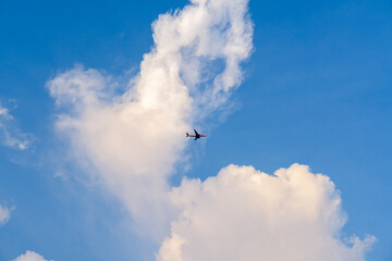 plane in the sky, airplane flying in the sky, airplane in the sky, blue sky with clouds, clouds in the sky, white clouds in the sky, clouds in the sky, blue sky with clouds