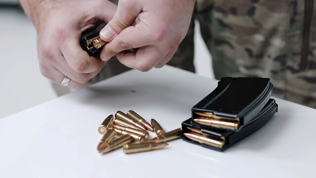 Hand taking ammo, bullets 762 caliber for ak47, gun crime military target war bullet weapon army military firearm, bullet pile, bullet shells, military concept, hunting ammo, close up