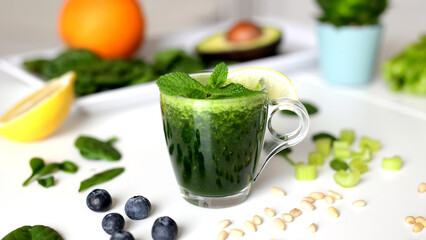 Pouring Organic Freshly Squeezed Green Vegetable and Fruit smoothie Into the jar. Healthy and vegetarian food concept