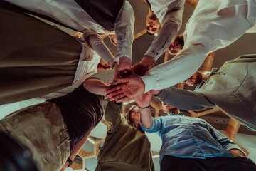 A group of young businessmen offer their hands together, symbolizing togetherness in the business world