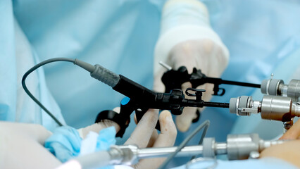 Close up of hands of surgeons team during operation uterus removal with surgical laparoscopy...