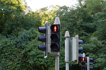 View on pedestrian traffic light with red stop signal in shape of man. Behind are other semaphores...