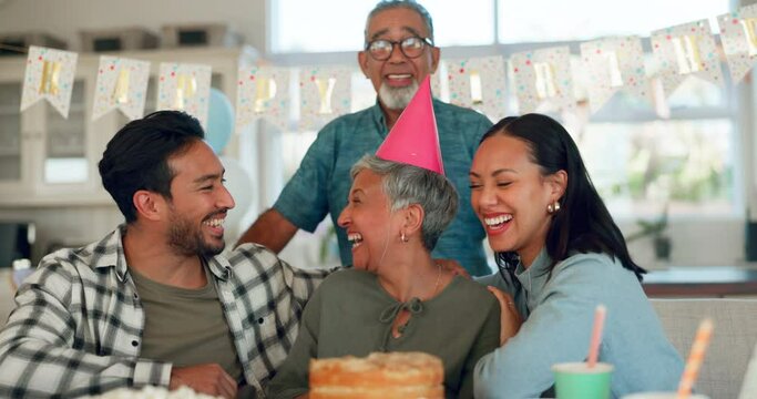 Senior family, birthday party and woman for celebration, kiss and love or support for retirement in home kitchen. Interracial people, elderly parents and happy women or men with cake for holiday