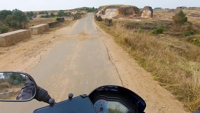 motorcycle rider ridding bike at remote tarmac at day from flat angle