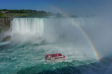 Niagara Falls, Ontario, Canada: A rainbow appears over the Niagara River as a tour boat takes visitors to the foot of the Horseshoe Falls.