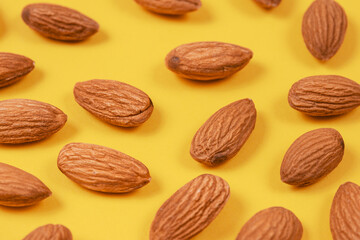 Almonds on a yellow background. 