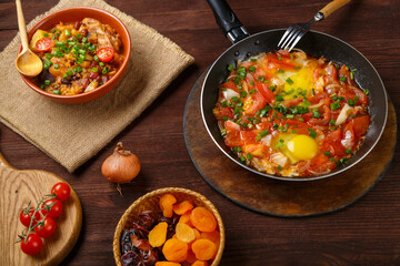 Jewish food hot cholent and shakshuka on a laid Shabbat table.