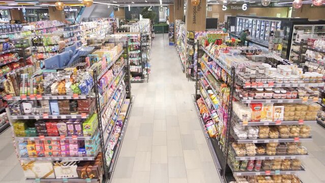 Food counters and shoppers in a supermarket. Timelapse
