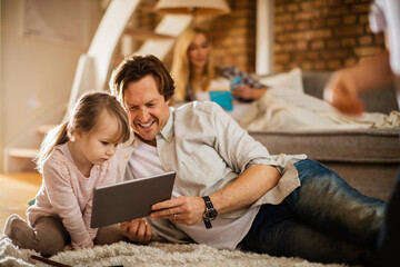 Family playing and using a tablet in the living room at home
