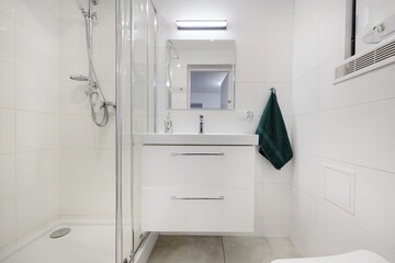 jasna biała łazienka z zielonym ręcznikiem