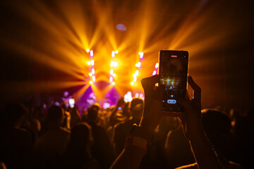Hands holding phone and making photos on the concert.
