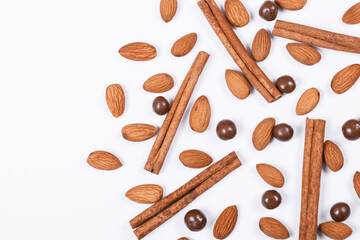 Almonds, cinnamon sticks and chocolate balls on a white background.