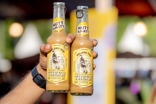 man holding two bottles of nutt khatt coffee a foodtech startup in India that has grown in popularity