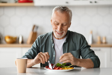Smiling Senior Man Eating Tasty Breakfast Or Lunch In Kitchen At Home
