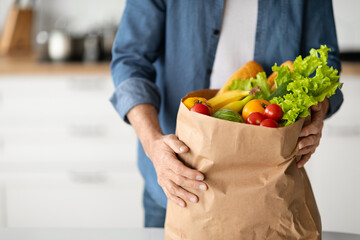 Market Delivery Concept. Unrecognizable Man Holding Paper Bag With Groceries In Kitchen