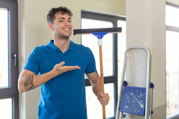 young handsome man smiling cheerfully, feeling happy and showing a concept. windows washer concept