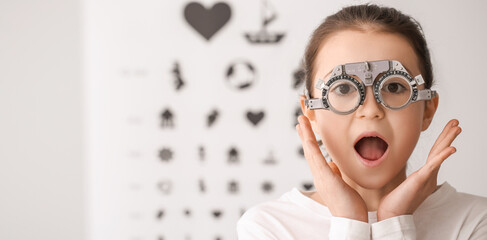 Surprised little girl undergoing eye test in clinic