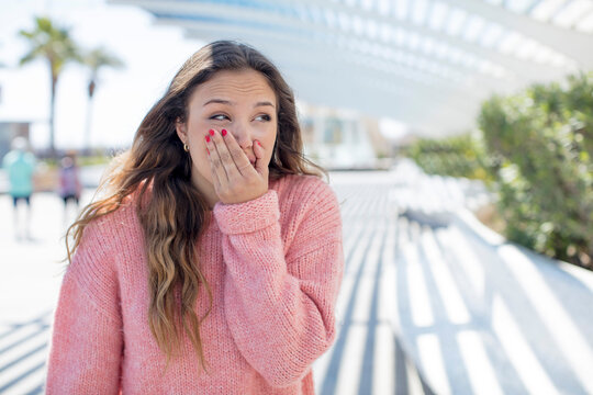 pretty hispanic woman covering mouth with hands with a shocked, surprised expression, keeping a secret or saying oops