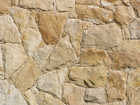 Light brown irregular stone wall. Quartz arenite building cladding.