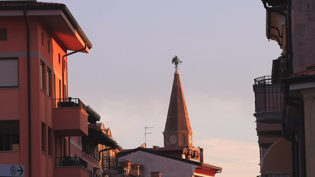 Bell tower with Statue portraying St. Michael and known as the Anzolo in  Grado at the top of The Basilica of Sant'Eufemia, Friuli-Venezia Giulia - Grado, Italy