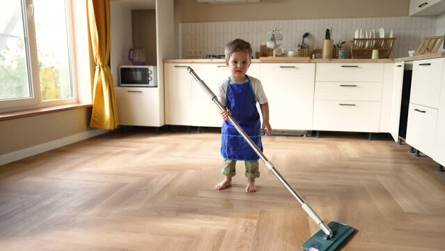 Happy children at home mopping floors.Clean house cleaning.Cute child work at home.Clean interior.Domesticated child washes floors with mop.Completion of assigned task.Teaching children about homework