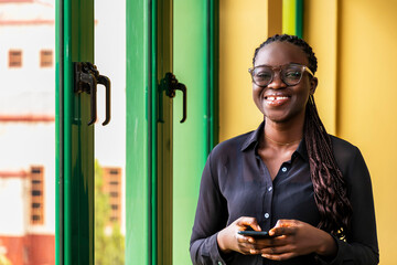 young businesswoman standing in front of a green and yellow wall