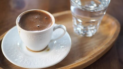 a cup of turkish coffee and water glass on table 