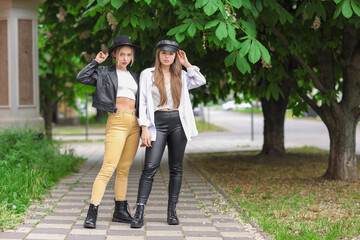 Fototapeta na wymiar Stylish young sisters on city street