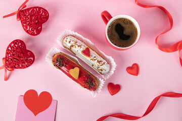 Festive eclairs decorated with hearts for Valentines Day as well as a cup of coffee on pink...