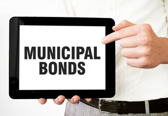 Fototapeta na wymiar Text MUNICIPAL BONDS on tablet display in businessman hands on the white background. Business concept