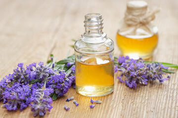 Lavender essential oil and extract in glass bottle with fresh flower and leaf on rustic wooden background, closeup, spa, skin care, aroma therapy, beauty treatment concept
