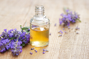 Lavender essential oil and extract in glass bottle with fresh flower and leaf on rustic wooden...
