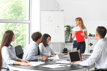 Female business consultant giving presentation to her colleagues in office