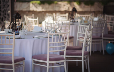 wedding chairs and details on summer wedding. ceremony decorations in restaurant. Elegant decoration of wedding ceremony outdoor. Wedding banquet with beautiful white furniture. 