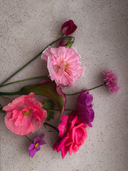 Beautiful pink rose, cosmos, poppy, sweet pea, cornflower flat lay on stone background. Stylish flowers still life in home, artistic composition. Floral vertical wallpaper
