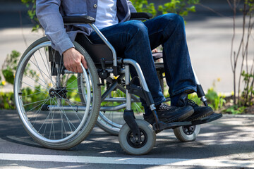Naklejka premium Unrecognizable man on wheelchair in park.