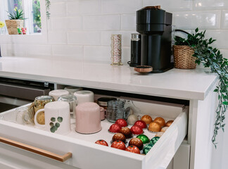 vue sur un comptoir de cuisine avec un tiroir ouvert nous montrant l'organisation des capsules à...