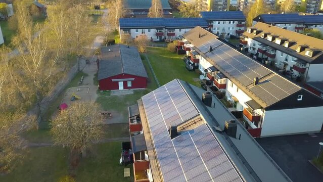 Solar photovoltaic panels mounted on roof of swedish condo building in Linkoping residential area. Renewable electricity development